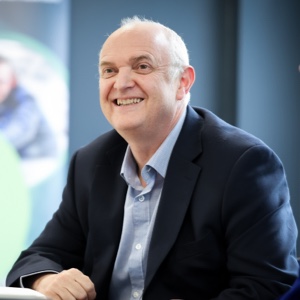 A person sitting at a desk smiling