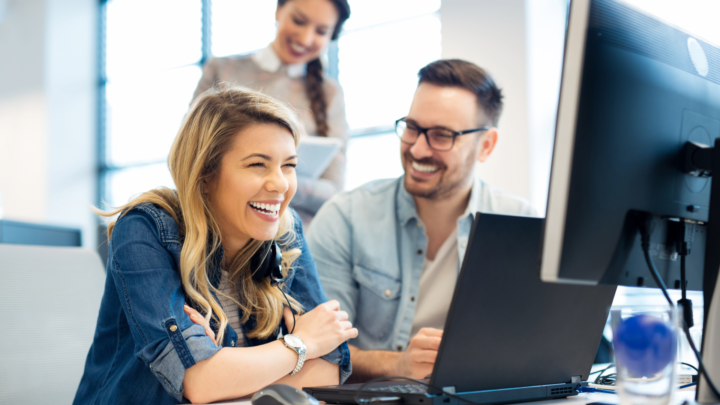Business team celebrating looking at computer screen