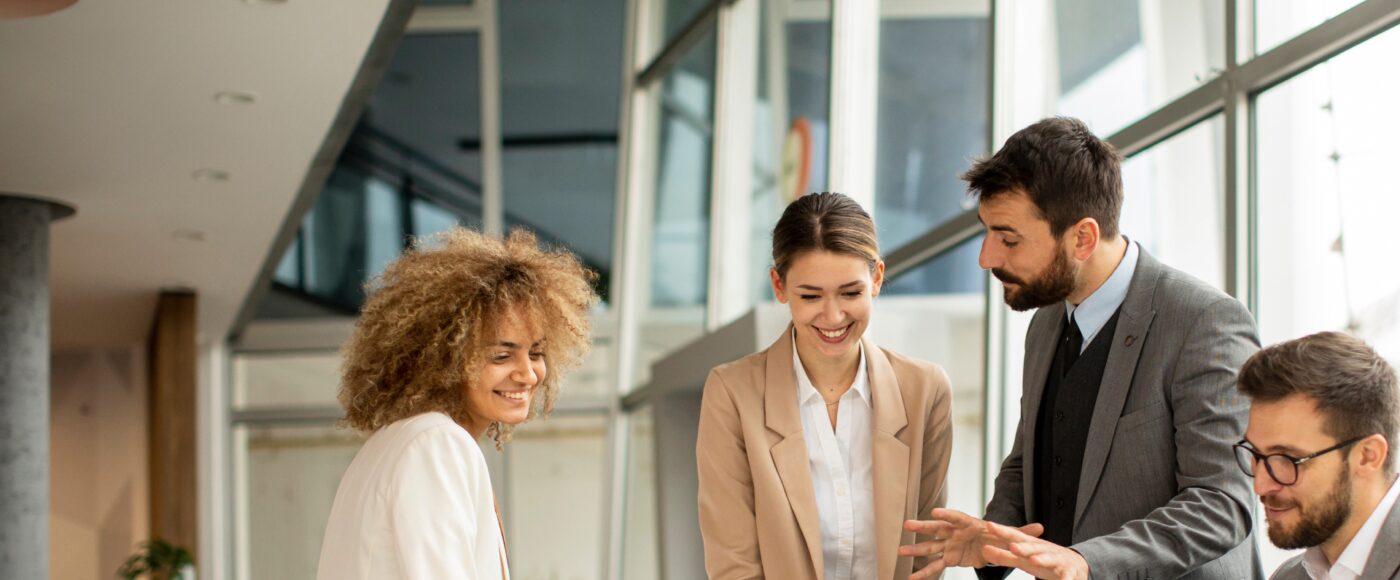 4 professionals working smiling on laptop