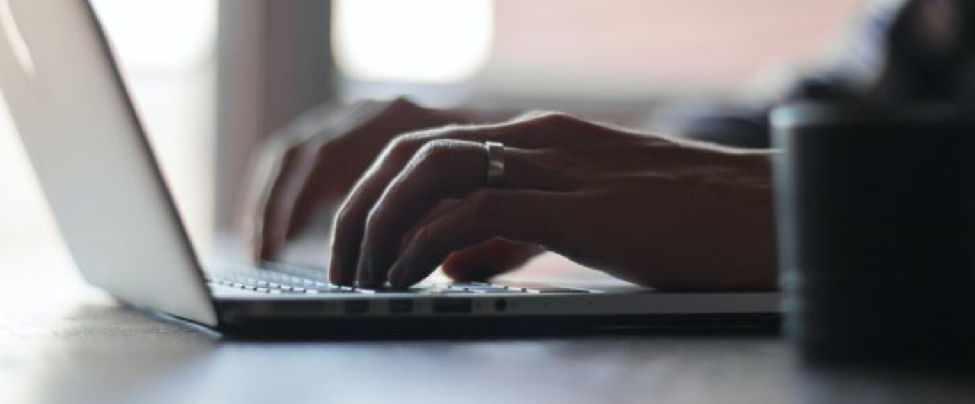 Image of person typing on laptop keyboard