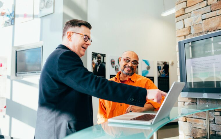2 Business men looking happy pointing to a laptop